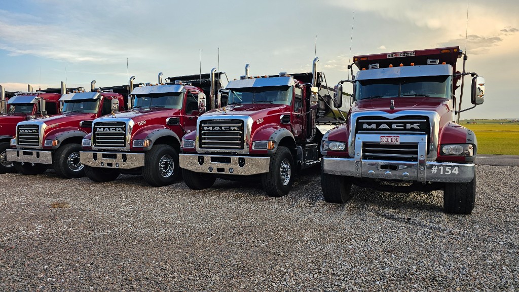 Four WayMaker dump trucks parked in a row
